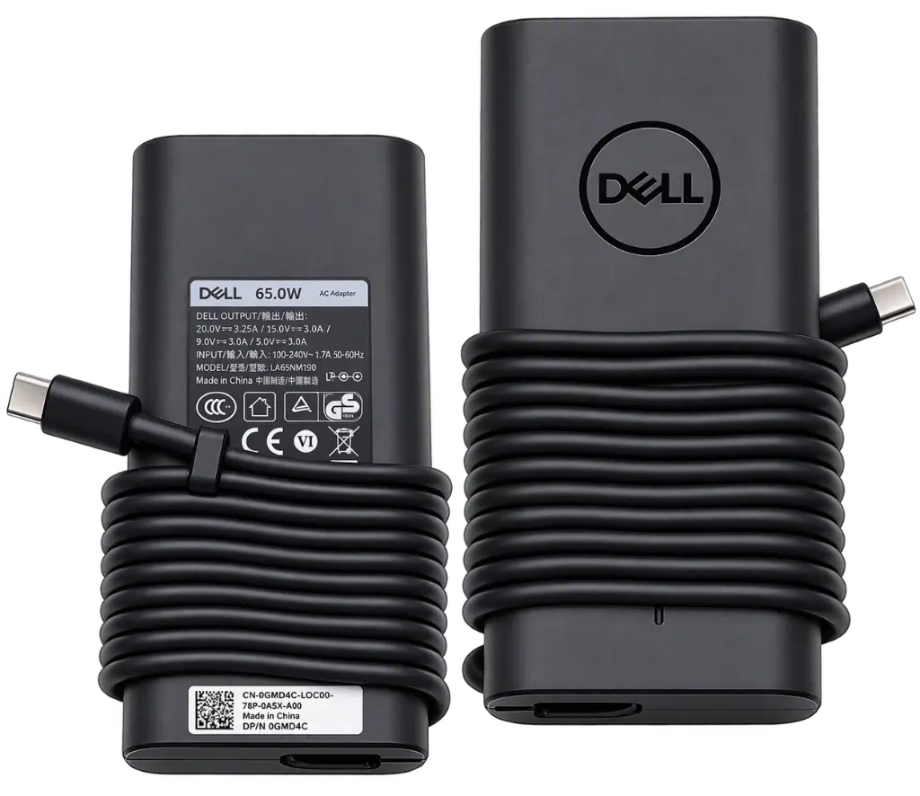A Dell 65W AC Power Adapter shown from both the front and back. The adapter is matte black with a coiled power cord, a USB-C connector on the left, and the Dell logo on the front face.