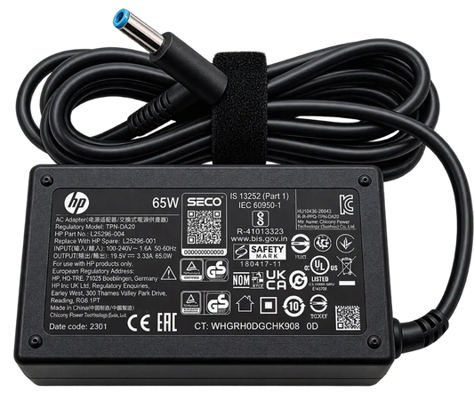 HP 65W AC Adapter power supply with a black cord and barrel connector, photographed on a white background. The product label shows HP, SECO, and other certification markings.