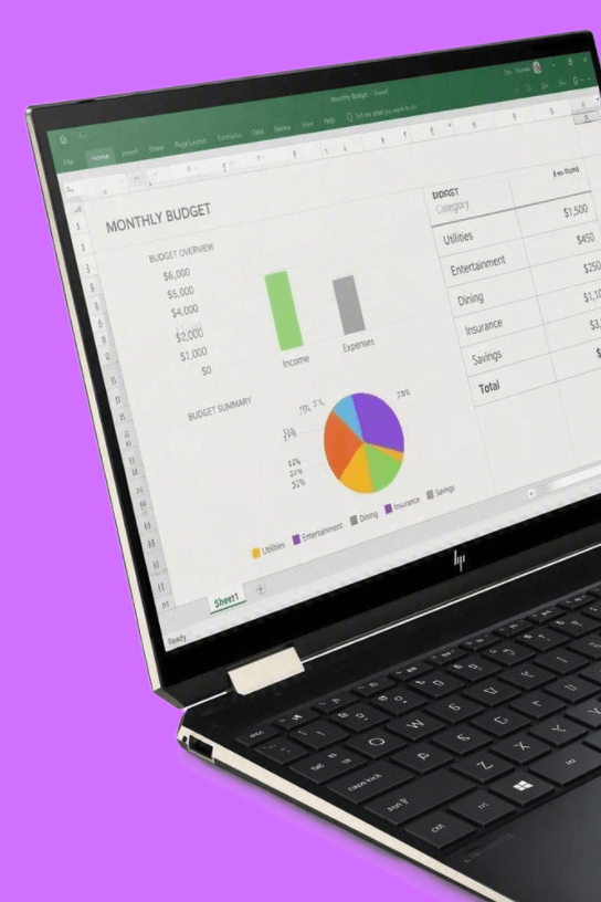 A black convertible laptop with a silver hinge, shown open and angled on a solid purple background. The screen displays a spreadsheet application interface.